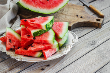 Fresh sliced watermelon in a metal bowl wooden background