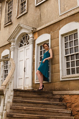 elegant young woman on stair of an old palace
