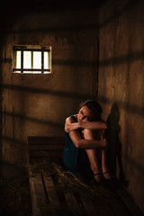Frightened young women in dark jail