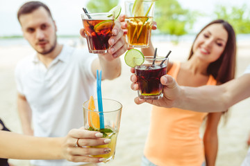 Friends having fun at the bar outdoors, drinking cocktails.