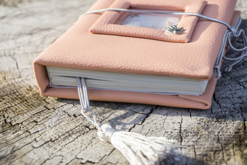 Fototapeta na wymiar Handmade pink leather notebook with decoration like shaker with paillettes and tassel