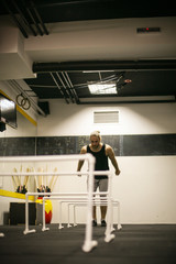 Young man jumping over obstacles in gym. Man in the gym.