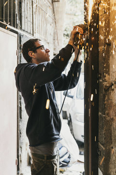 Blacksmith working with disc grinder outdoors