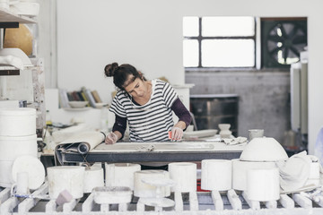 Female ceramic artist working on a sheet of clay