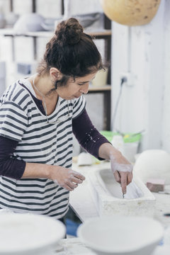 Female ceramic artist working on a mould