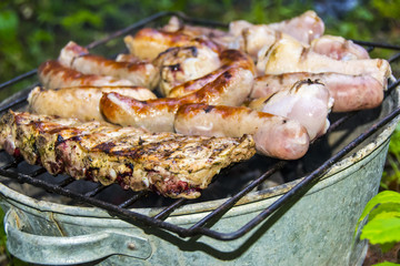 Sausages pork ribs chicken legs on the grill barbecue