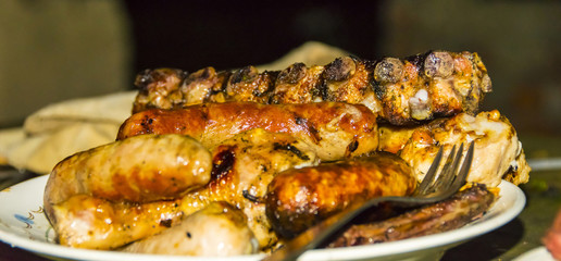 Sausage pork ribs chicken legs on the grill barbecue on plate
