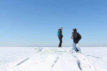Man, woman and child walking on an ice floe on a snowy river in the winter, Ob River, Russia