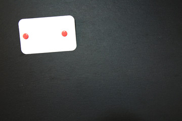 Schiefertafel mit angeheftetem leerem Notizzettel