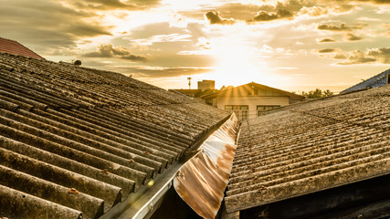 Old roof tile on the houses with sun light, sunset, home style of thai people, vintage style.