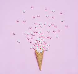 Pink and white Marshmallows in waffle cone on pink background. Top view, flat lay. free space for your text