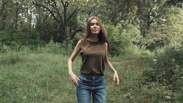 Sexy tourist walking in park after lessons, student portrait, Dynamic pretty woman in a forest in slow motion
