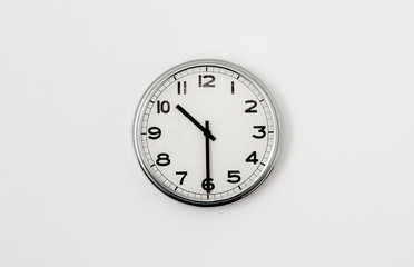 White Clock hanging on a white wall showing time 10:30