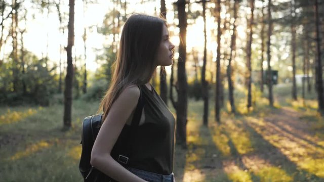Sexy tourist walking in park after lessons, student portrait, Dynamic pretty woman in a forest in slow motion