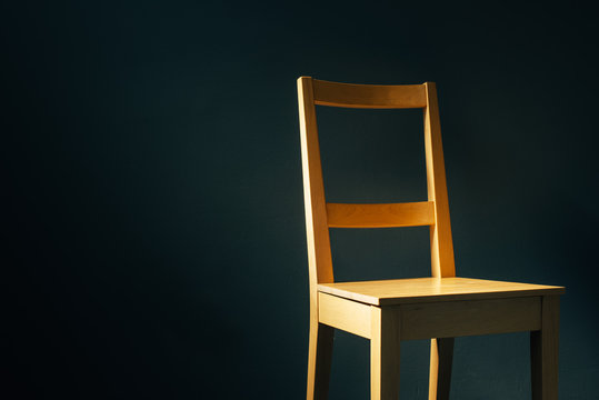 Empty Wooden Chair In Dark Room