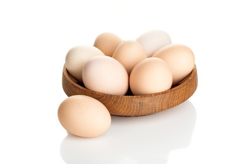 chicken eggs in a wooden plate isolated on white background