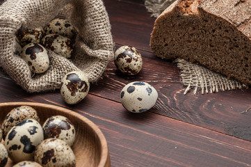 quail eggs in burlap sack over old wooden background