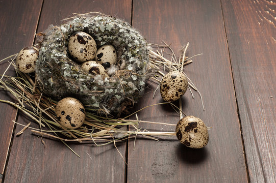 quail eggs in a nest over old wooden background
