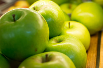 Group of ripe green  apples on wooden tray