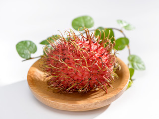 rambutan with vanilla on wooden plate isolated on the white background .