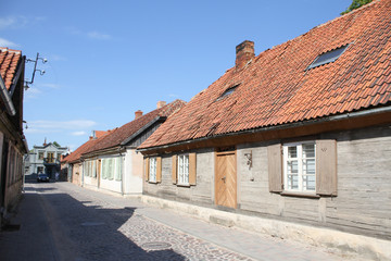 Small city brick road with old wood houses with classic rooftop with tiles.