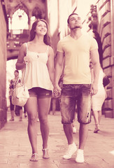 Fototapeta na wymiar Couple walking through city