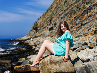 girl sitting on a rock by the sea