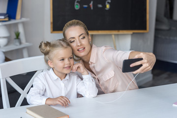 mother and daughter using smartphone