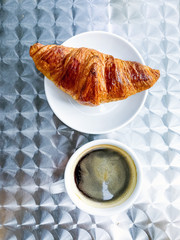 Breakfast with coffee and croissants on table