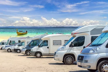 Foto op Plexiglas Close up motorhomes parked in a row on white sand beach and blue sky background. © Southtownboy Studio