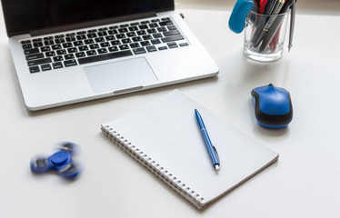 work desk with laptop mouse and spinner