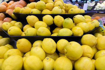 Fresh raw lemons display for sale in supermarket