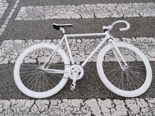 Fototapeta premium White bicycle in the soil of asphalt