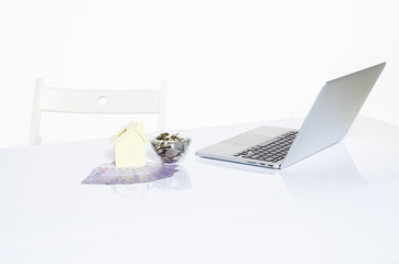 Coin in glass with banknotes and laptop on reflection table ideal for saving and home investment concept