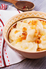 Varenyky, vareniki, pierogi, pyrohy or dumplings, filled with potato and served with salty caramelized onion
