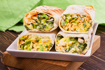 Wraps with chicken, avocado, cilantro and cheese. Chicken burrito