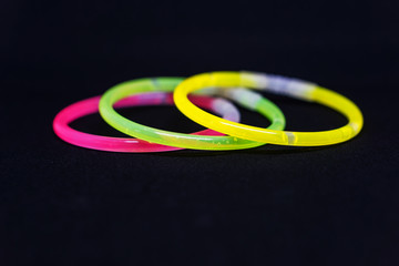 Trendy color, neon bracelets, on black background. Beuty fashion concept. Shallow depth of focus.