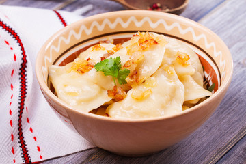 Varenyky, vareniki, pierogi, pyrohy or dumplings, filled with potato and served with salty caramelized onion