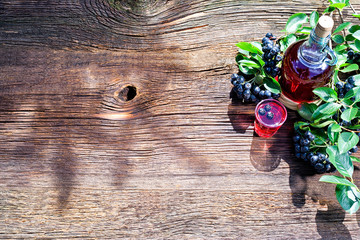 A glass of tincture of chokeberry. Free space for your text. Wooden background.