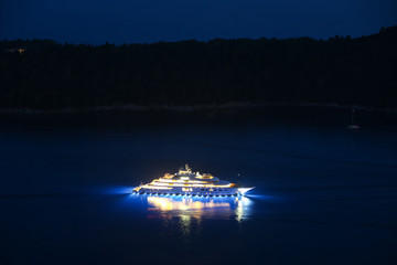 An illuminated luxury yacht in the Adriatiac sea at night in Dalmatia, Croatia.