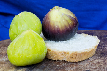 fresh tasty figs friuts on a wood plate with a blue background.