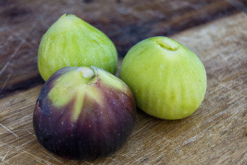 fresh tasty figs friuts on a wood plate with a blue background.