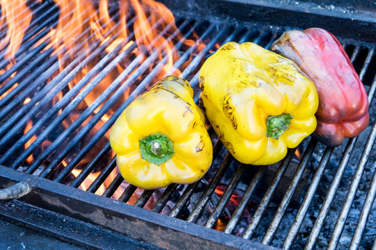 tre peperoni colorati su barbecue a fuoco molto alto a legna 