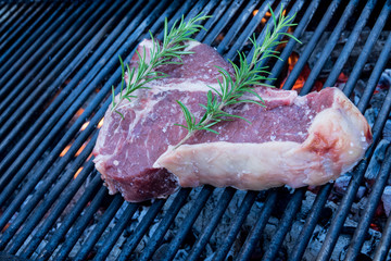 bistecca fiorentina motlo grande sulla griglia a fuoco motlo fortecon barbecue ,rosmarino e sale 