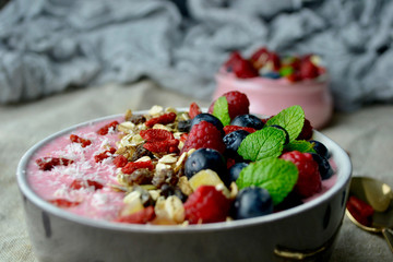 Smoothie Bowls with Raspberries, Blueberries, Goji Berries, Granola and Mint.Fresh Fruit Heath Breakfast