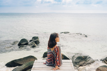 The beautiful woman sitting on the wooden  bridge near the beach in Koh munnork island, Thailand.