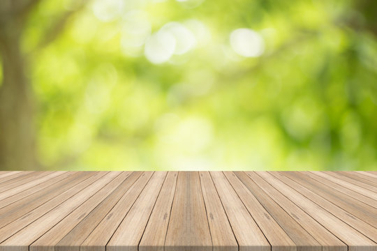 Empty wood table top on blurred abstract green background,Free space for editing products.