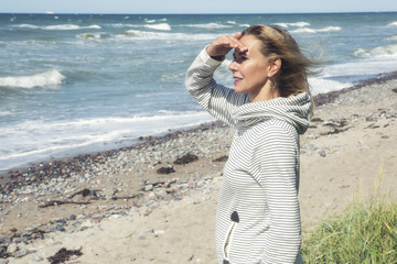 woman standing on beach and looking into the distance