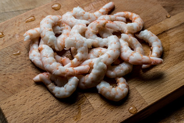 Shrimps with lime on wooden surface.