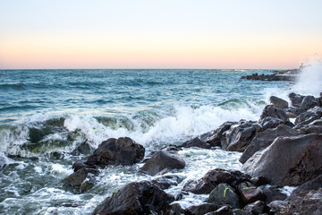 Fototapeta na wymiar Sea waves in sunset with rocks and stones. Nature landscape.